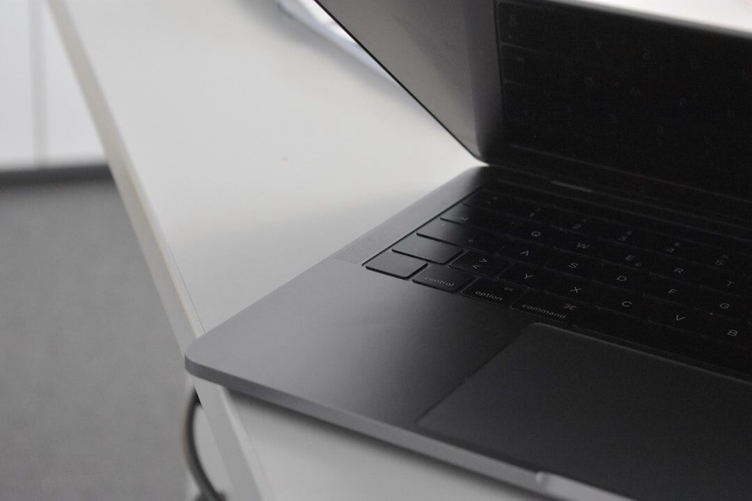 Close up of hands typing on a laptop in a modern office